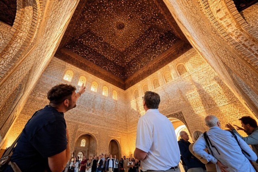 A group of people inside a building with intricate architectural details, including a starry ceiling and ornate walls. 2