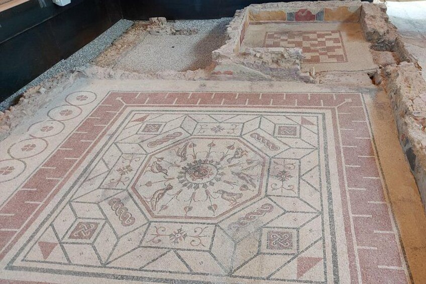 Een oude mozaïekvloer met geometrische patronen en een centraal bloemenontwerp. 2