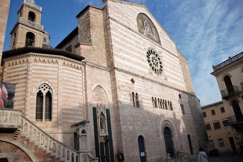 A historic church with a bell tower and a large rose window. 3