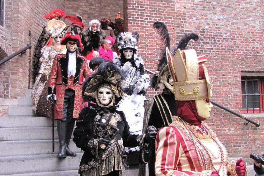 A group of people in elaborate historical costumes descending a brick staircase. 1