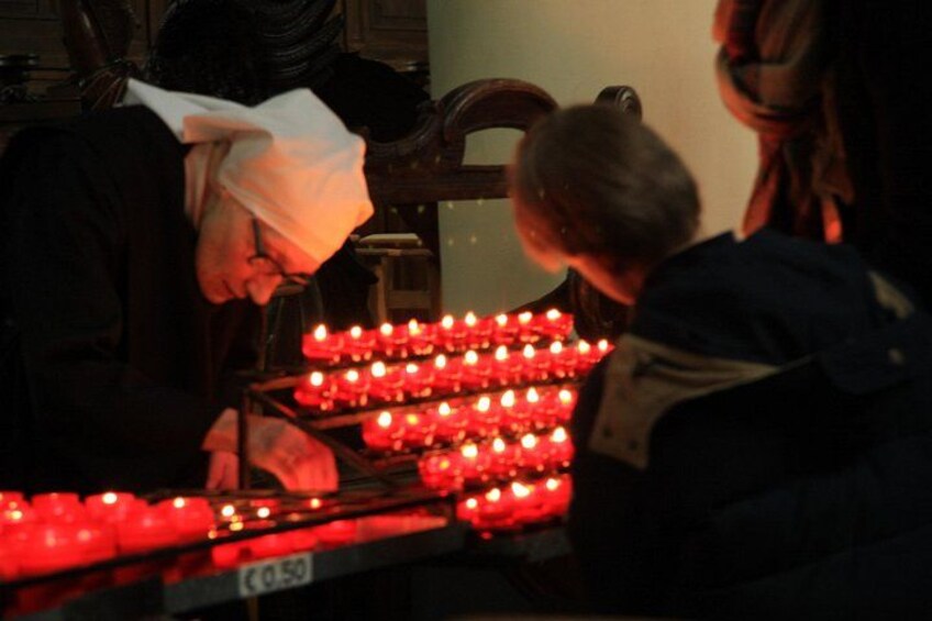 A person lighting candles in a row. 5