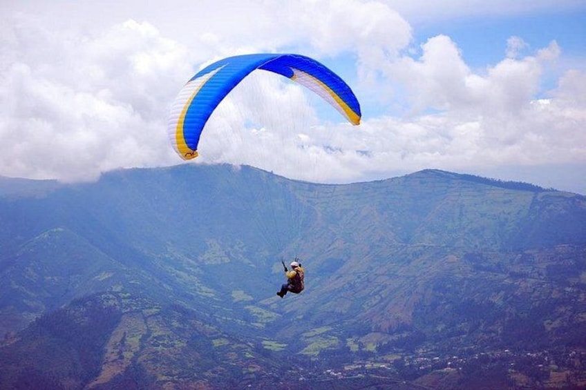 Iemand paraglidet boven een bergachtig landschap. 1