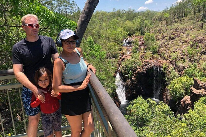 Una famiglia in piedi su un ponte, con una cascata sullo sfondo. 5