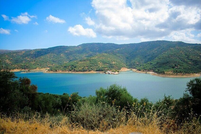 Un lago rodeado de colinas y vegetación. 5