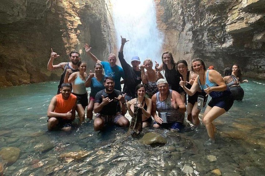 Un groupe de personnes se trouve dans un canyon rocheux, près d’une cascade. 1
