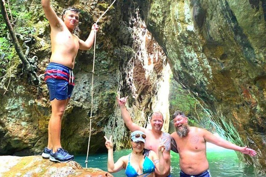 Un groupe de personnes se trouve près d’une falaise rocheuse, avec de l’eau en contrebas. 4