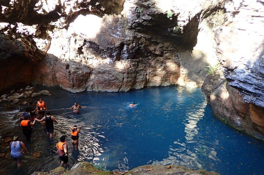 Un grupo de personas en una masa de agua natural rodeada de acantilados rocosos. 1
