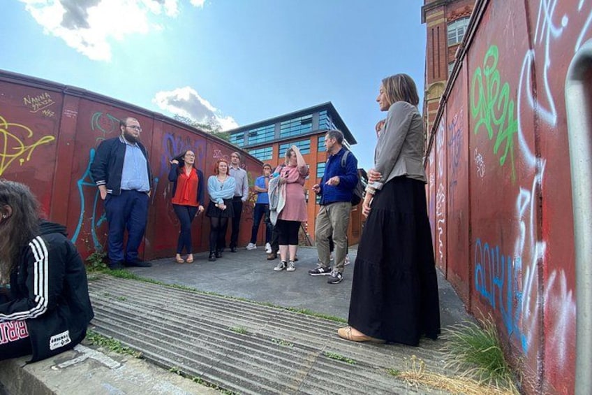 En gruppe mennesker står på en trappe ved siden af en væg med graffiti. 2