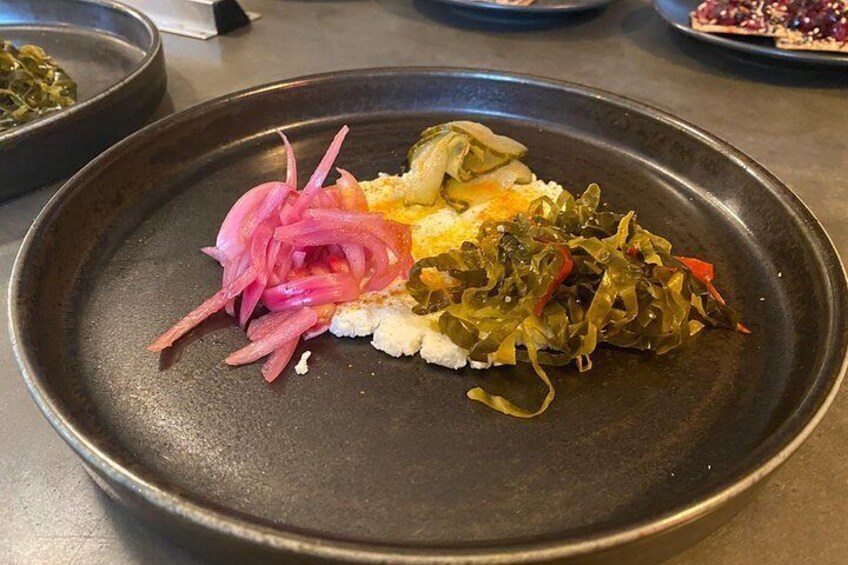 A plate with white rice, pickled vegetables, and seaweed. 2