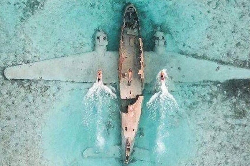 A submerged aircraft with two people in the water. 2