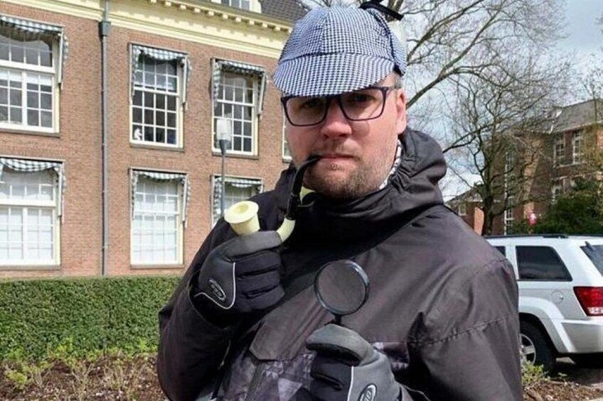 A person wearing a black jacket and a checkered hat, holding a camera. 2
