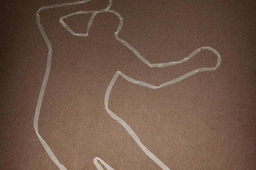 A chalk outline of a person on a brown surface. 2