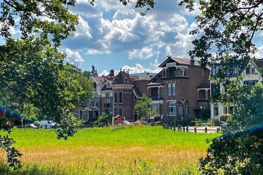 A row of Victorian-style houses with a green field in the foreground. 4