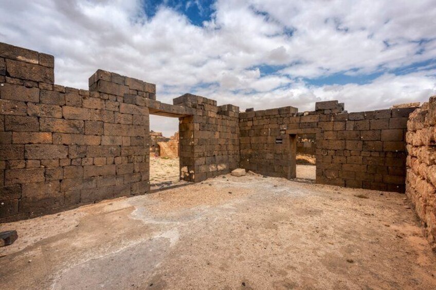 An ancient stone structure with walls and an open doorway. 5