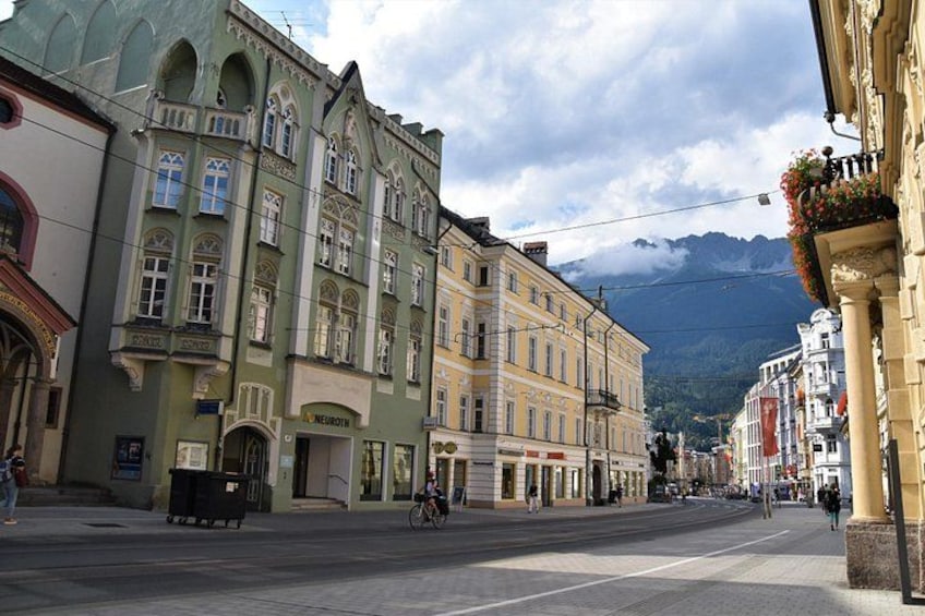 A street with historic buildings, a cyclist, and a mountain in the background. 4