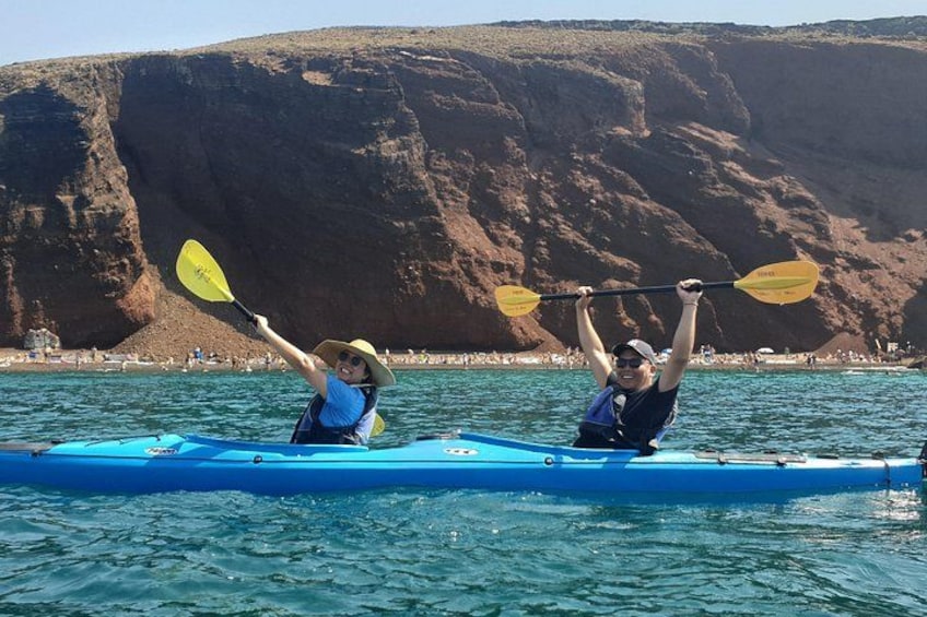 Deux personnes pratiquent le kayak sur une étendue d’eau calme, avec une falaise rocheuse en arrière-plan. 2