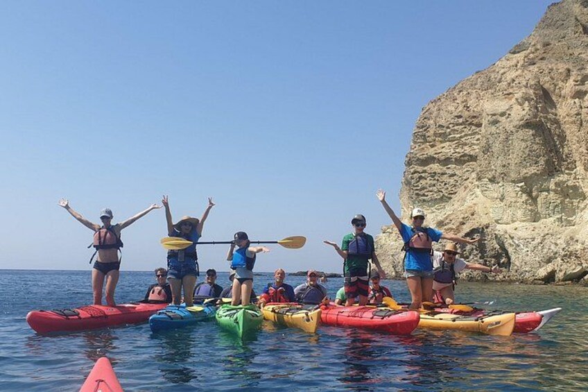 Des personnes pratiquent le kayak sur une étendue d’eau calme, avec une falaise rocheuse en arrière-plan. 3