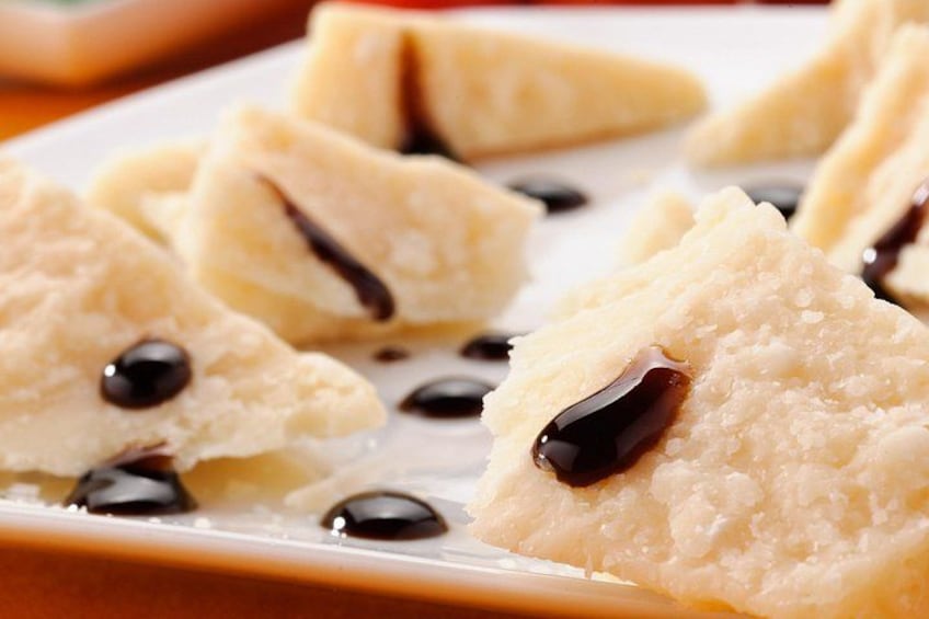 A plate of triangular pastries with a dark filling and chocolate syrup. 2