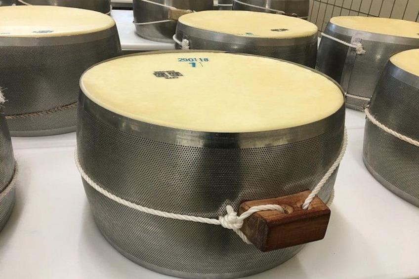 Eine Trommel mit einem daran befestigten Holzklotz. 2
