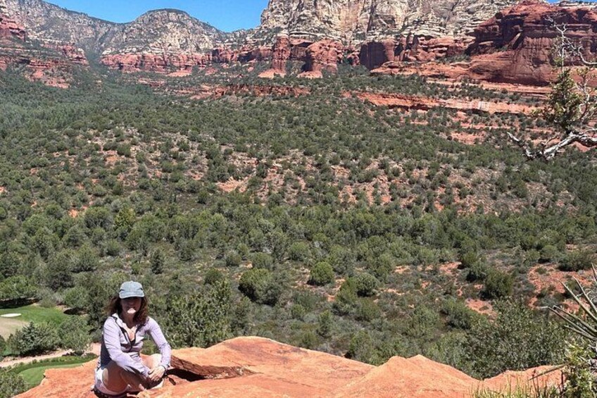 Una persona sentada sobre una roca, con un paisaje montañoso al fondo. 2