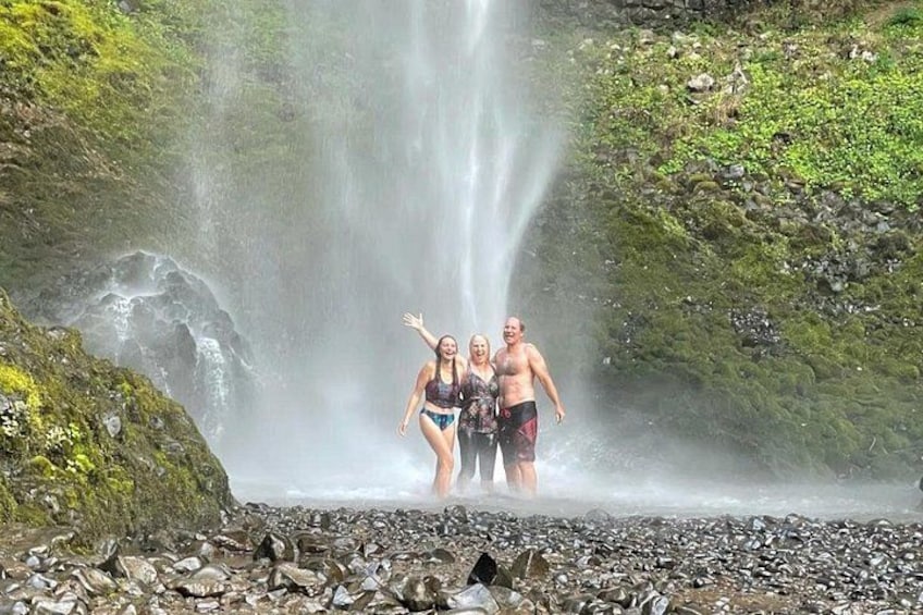 A waterfall, rocky terrain, and a person standing in the water. 5