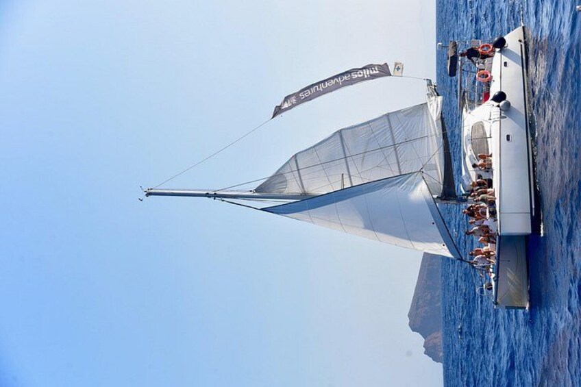 Un velero con una vela grande y un estandarte, navegando sobre aguas azules. 5