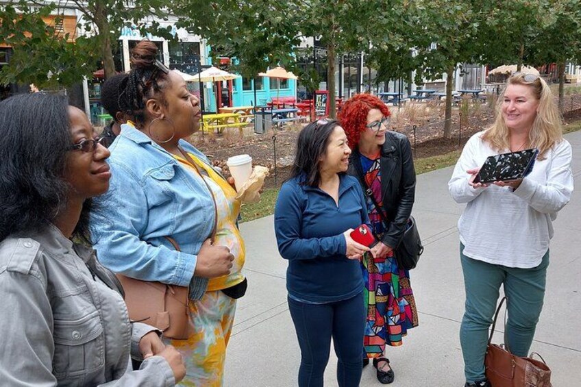 A group of people standing on a sidewalk in an urban park. 2