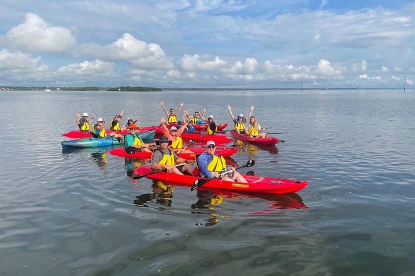 A group of people kayaking on a calm body of water. 1