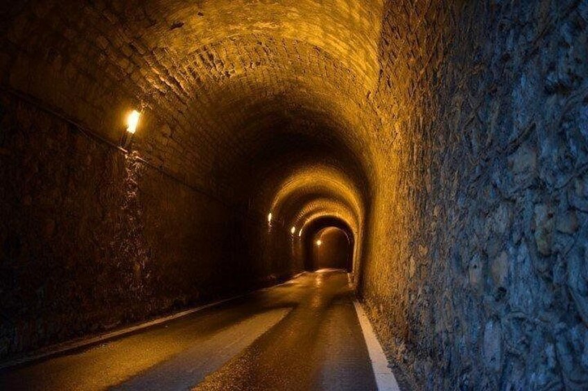 A tunnel with stone walls and a road. 2