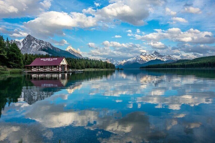 Une cabane au bord d’un lac, avec des montagnes en arrière-plan. 4