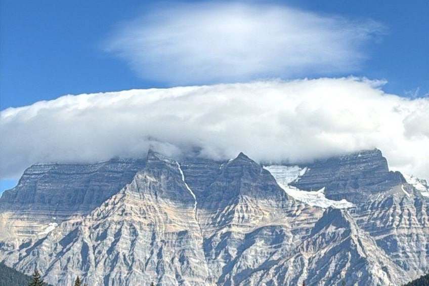 Une chaîne de montagnes dont les sommets sont enneigés et qui s’étend sous les nuages. 2