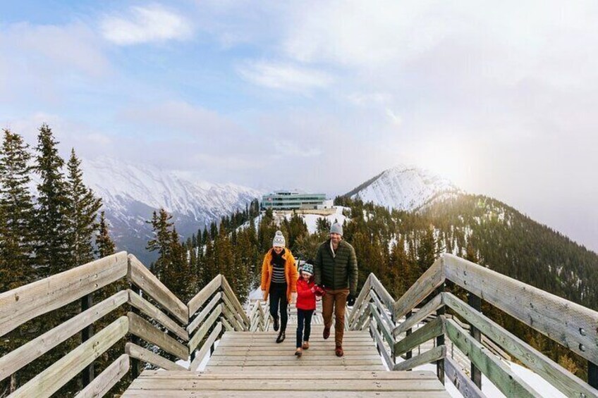 Una escalera de madera que asciende una montaña con picos nevados al fondo. 4