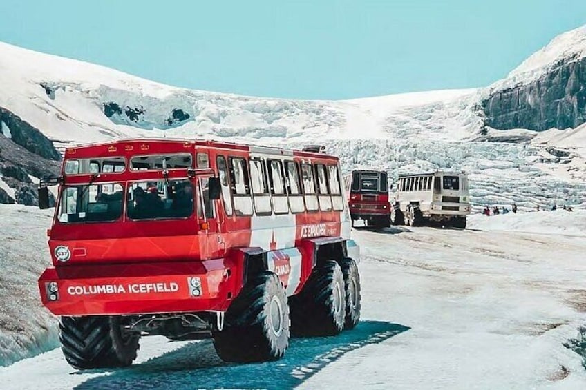 A red vehicle labeled 'Columbia Icefield' on a snowy road with a mountainous backdrop. 2