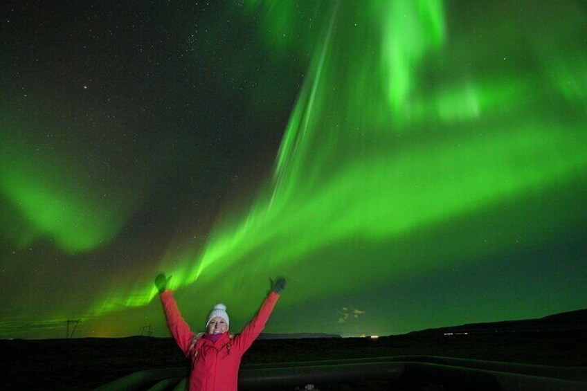 A person with arms raised under the Northern Lights. 1
