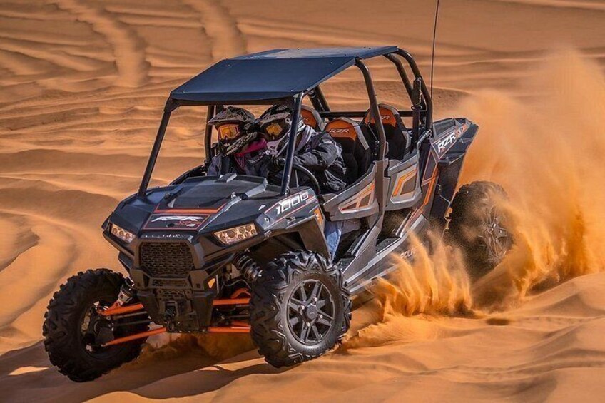 A quad bike in a desert with sand being kicked up. 2
