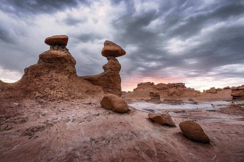 A desert landscape with rock formations and a cloudy sky. 5