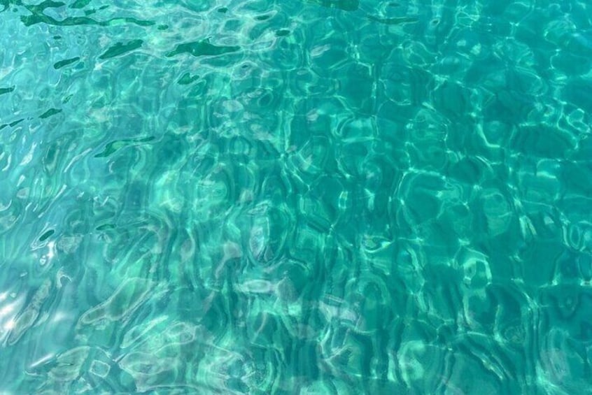 Klares, türkisblaues Wasser mit sichtbaren Wellen und Spiegelungen. 5