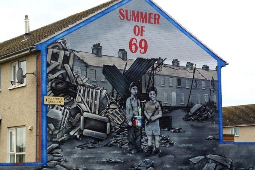 A mural on a building depicting a scene with two children and a pile of debris, with the text 'SUMMER OF 69' at the top. 3