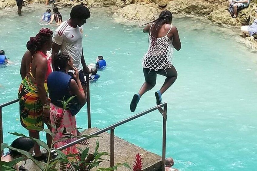 A person jumping into a pool from a diving board. 1