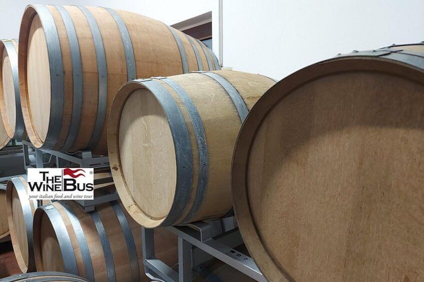 Wooden wine barrels stacked on metal racks. 4