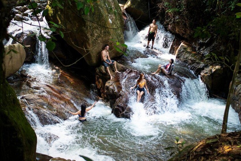 A waterfall with people enjoying the water. 1