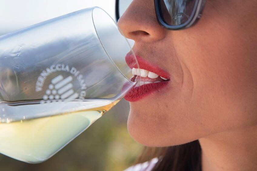 Een persoon houdt een glas met een logo vast en drinkt eruit. 3