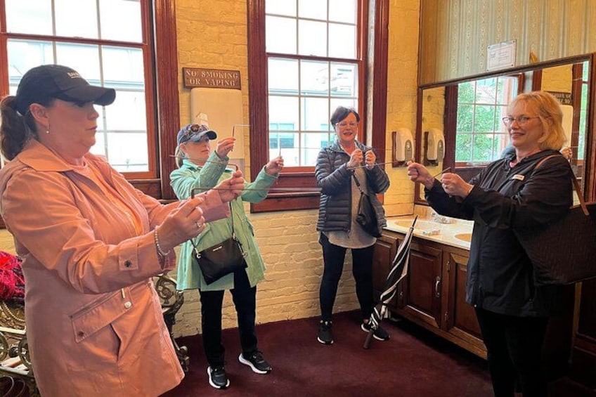 A group of people in a room with large windows and wooden cabinets. 3