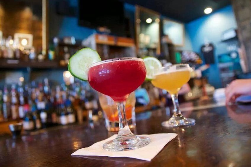 Un bar où l’on peut voir trois cocktails alignés sur le comptoir. 5