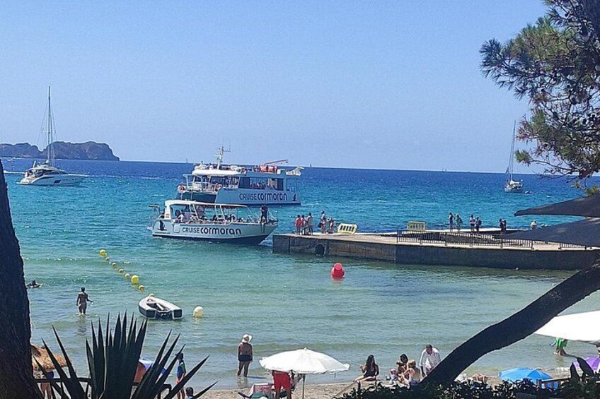 A coastal scene with boats, a pier, and people. 2