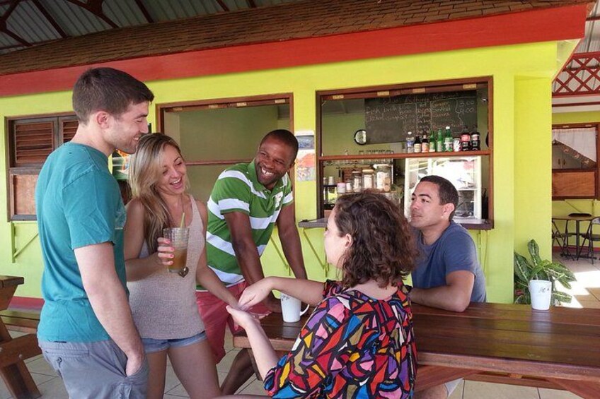 A group of people at a bar with a chalkboard menu and a counter. 1