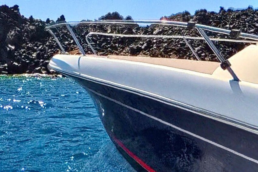 A boat with a metal railing, water, and rocky coastline. 3