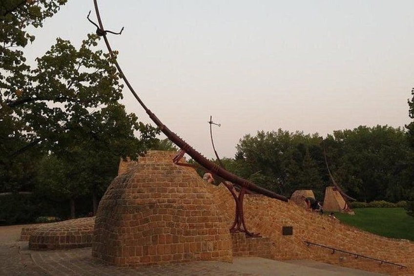 A brick structure with a leaning tree. 4