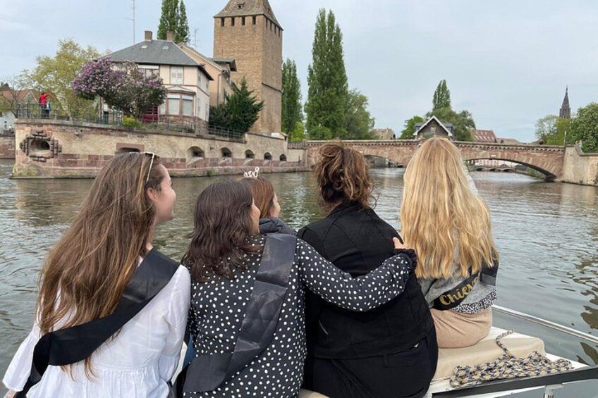 Quatre personnes à bord d’un bateau, un pont et une tour en arrière-plan. 4