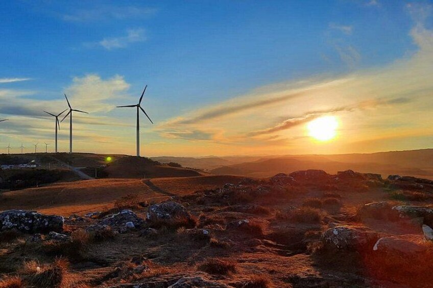 Wind turbines, a sunset, and a rocky landscape. 5